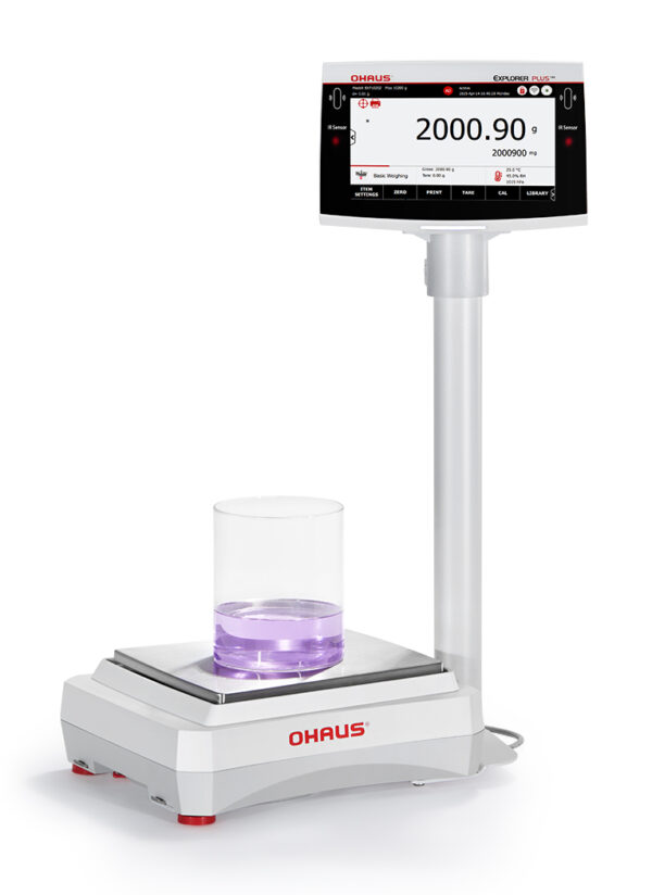 Ohaus Explorer Precision Balance viewed side on with indicator on a pillar beaker with purple liquid in situ. White background.